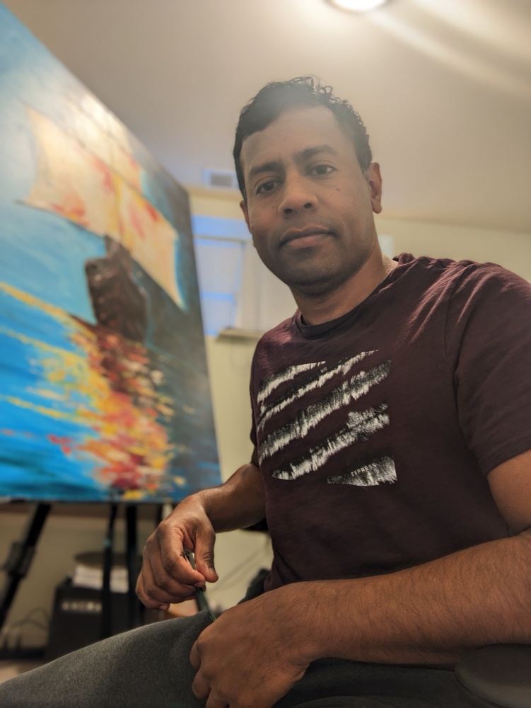 Daniel Pandiyan beside one of his paintings